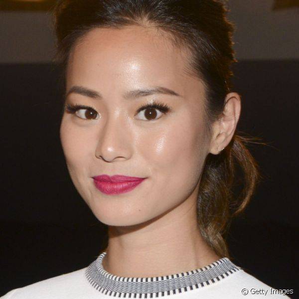 A atriz Jamie Chung adicionou cor ao seu look branco com um rosa vibrante nos l?bios e sombra preta nos olhos